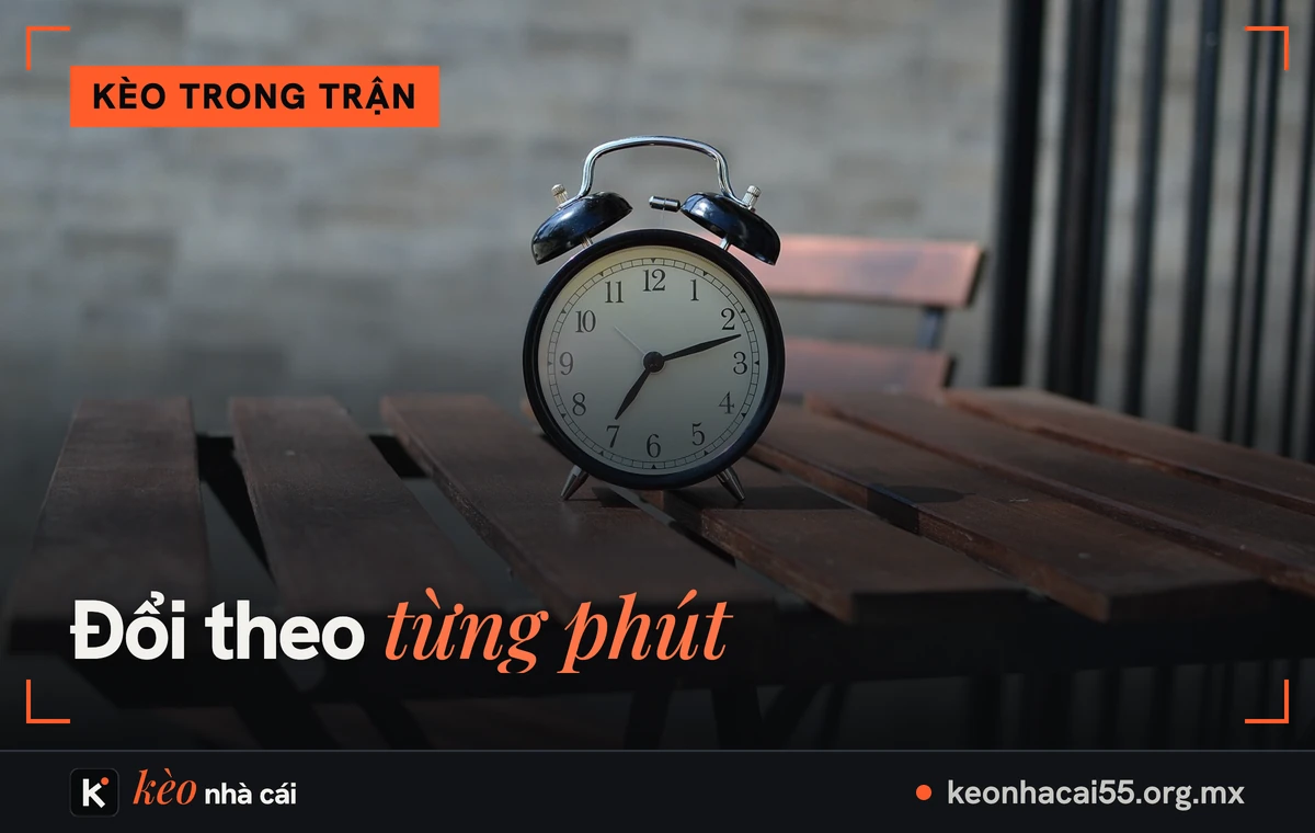 Đồng hồ báo thức trên bàn gỗ, kèo trong trận đổi theo từng phút